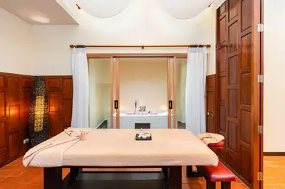 a room with a table and a bed in a room at Dewa Villa in Nai Yang Beach