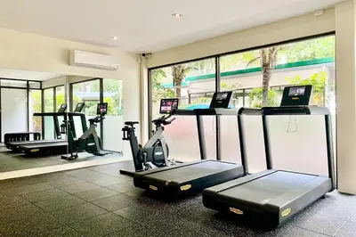 a gym with two treadmills and two exercise bikes at Dewa Phuket - Deluxe Garden in Nai Yang Beach