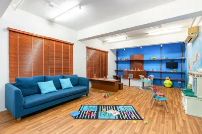 a living room with a blue couch and a table at Dewa Phuket - Deluxe Garden in Nai Yang Beach