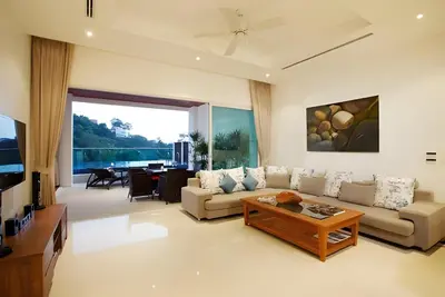 a living room with a couch and a table at Sea View Pool Villa Grand Kamala Falls in Kamala Beach