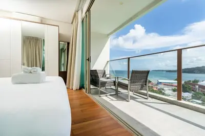 a bedroom with a bed and a view of the ocean at Elegant 2BR Oceanview Condo Oceana C73 - 5 min walk Kamala Beach in Kamala Beach