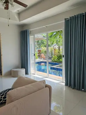 a living room with a couch and a sliding glass door at Private Tropical Villa 2bdr Bangtao beach in Laguna Phuket