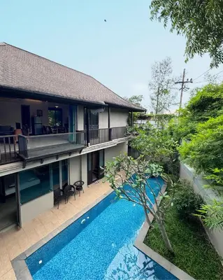 a villa with a swimming pool in front of a house at Bukitier Luxury Pool Villa Bangtao in Bang Tao Beach