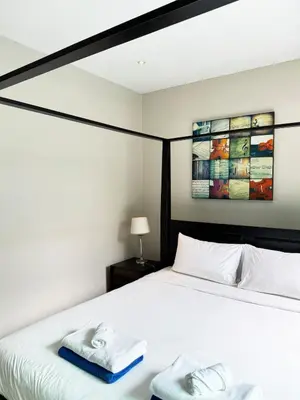 a bedroom with a white bed with towels on it at Bukitier Luxury Pool Villa Bangtao in Bang Tao Beach
