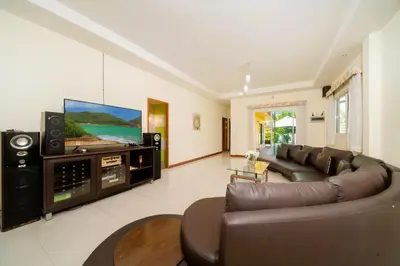 a living room with a couch and a flat screen tv at Mediteranean style 3 BR Pool Villa Platinum with garden in Rawai Beach