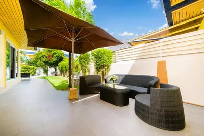 a patio with two chairs and an umbrella at Mediteranean style 3 BR Pool Villa Platinum with garden in Rawai Beach