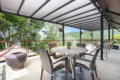 a patio with a table and chairs on a balcony at 5 BR Villa Kalim 5 Private Pool with Seaview in Patong Beach
