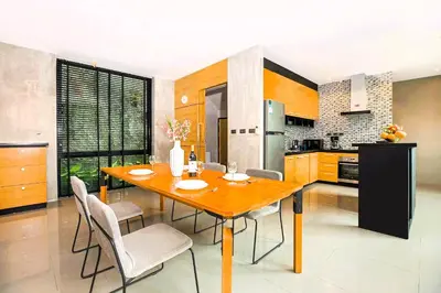 a kitchen with a wooden dining table and chairs at Nature-Inspired 2BR Duplex P12 with pool and gym in Kamala Beach
