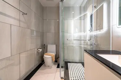 a bathroom with a toilet and a glass shower at The Title Legendary Bangtao by Beringela in Bang Tao Beach