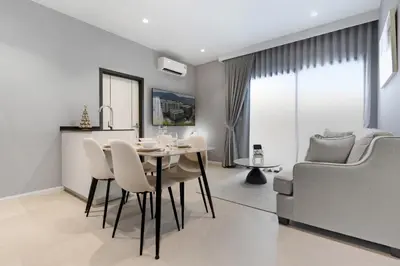 a dining room and living room with a table and chairs at The Title Legendary Bangtao by Beringela in Bang Tao Beach