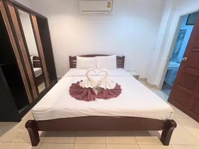 a bed with two white swans forming a heart at P&I Group Karon Beach Room-1 in Karon Beach