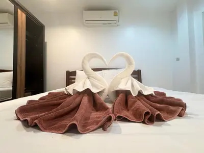two swans sitting on top of a bed at P&I Group Karon Beach Room-1 in Karon Beach