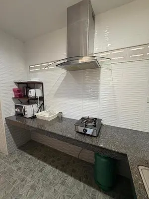 a kitchen with a counter top with a stove at Cozy 1-Bedroom apartment in Surin Beach