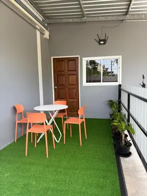 a table and chairs on a balcony with green grass at Cozy 1-Bedroom apartment in Surin Beach