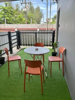 a patio with a table and chairs on the grass at Cozy 1-Bedroom apartment in Surin Beach