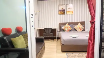 a bedroom with a bed and a chair and a table at Wings Alley Phuket in Phuket