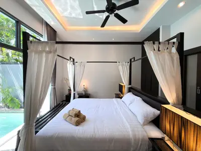 a bedroom with a bed with a teddy bear on it at Villa 2BD Nai Harn Beach by Mill in Ban Saiyuan (1)