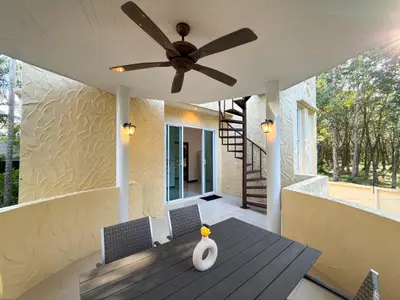 a ceiling fan on a porch with a table and chairs at Nai Harn Family Pool Villa 3 BDR by Mill in Ban Saiyuan (1)