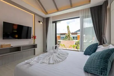 a bedroom with a large bed with a large window at Kiang Tawan Villa in Kamala Beach
