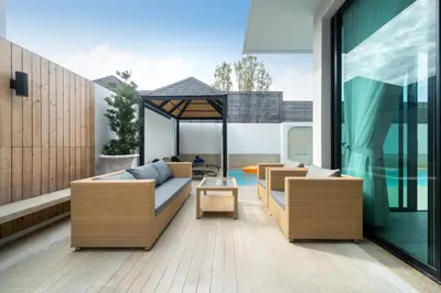 a patio with wicker furniture and a gazebo at Wanila Villa Bangtao Beach Brand New Luxury Modern Pool Villa Laguna Phuket in Thalang