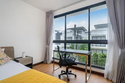 a bedroom with a desk and a large window at Happy 3 bedroom Townhouse Laguna Park in Laguna Phuket