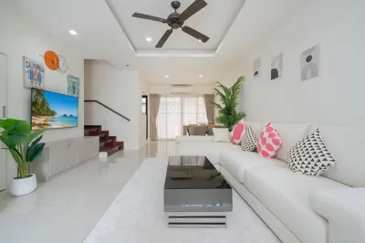 a living room with a white couch and a ceiling fan at Happy 3 bedroom Townhouse Laguna Park in Laguna Phuket
