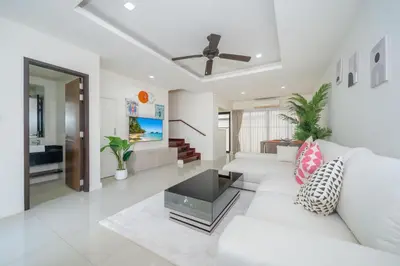 a living room with a white couch and a table at Happy 3 bedroom Townhouse Laguna Park in Laguna Phuket
