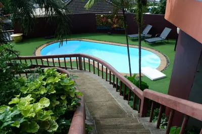 a small swimming pool with a wooden fence around it at The Cozy House in Karon Beach