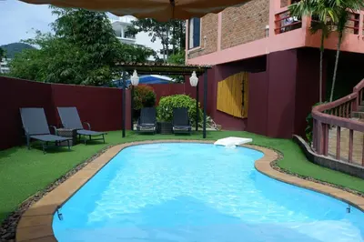 a swimming pool in the yard of a building at The Cozy House in Karon Beach