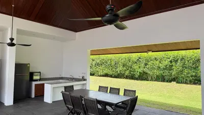 a kitchen and dining room with a table and a ceiling fan at The Majestic Estate - 6 Bedroom Private Villa in Ban Bang La