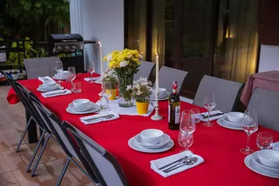 a table with a red table cloth with plates and wine glasses at Ton Sai Villa - 7 bedroom pool villa - Paklok in Ban Chin Tham Mai