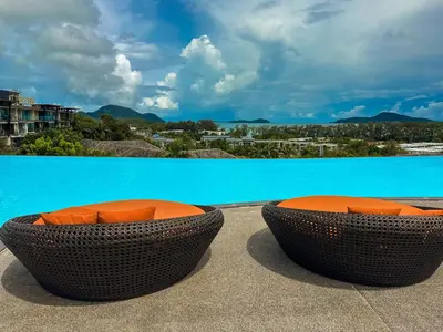 two orange bowls sitting on a ledge next to a pool at Large Lux Studio in La Vita 5-star Rawai in Rawai Beach