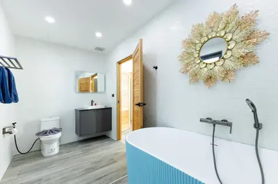a bathroom with a tub and a mirror on the wall at Modern 4-Bedroom Solar Villa with Pool & Game Zone at Sunset Garden 15 in Rawai Beach