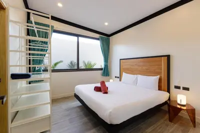 a bedroom with a bed and a book shelf at Modern 4-Bedroom Solar Villa with Pool & Game Zone at Sunset Garden 15 in Rawai Beach