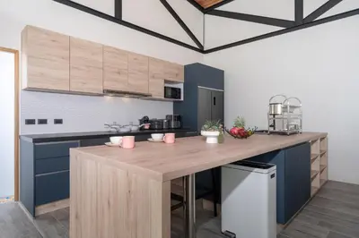 a kitchen with blue cabinets and a wooden counter top at Sunset Garden 16 - Eco Design Villa with Private Pool near Nai Harn Beach in Rawai Beach