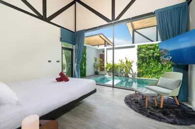 a bedroom with a bed and a swimming pool at Sunset Garden 16 - Eco Design Villa with Private Pool near Nai Harn Beach in Rawai Beach