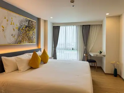 a bedroom with a large white bed with yellow pillows at Luxury 5-star Duplex in La Vita Sea View in Rawai Beach