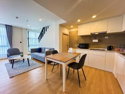 a kitchen and a living room with a table and chairs at Luxury 5-star Duplex in La Vita Sea View in Rawai Beach