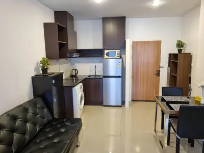 a kitchen with a couch and a refrigerator in a room at Karon Chic Seashore Apartment in Karon Beach