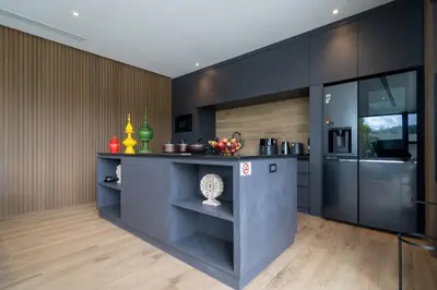 a kitchen with black cabinets and a counter top at Cocoon Villa 5 - Luxurious 3BR Pool Retreat near Naithon Beach in Nai Thon Beach