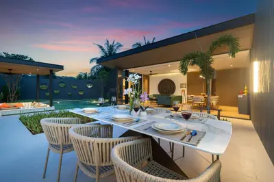 an outdoor dining area with a white table and chairs at Cocoon Villa 5 - Luxurious 3BR Pool Retreat near Naithon Beach in Nai Thon Beach