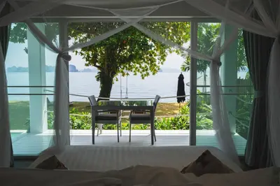 a bedroom with a bed and a table and chairs at Coastal Escape Koh Yao Noi in Ko Yao Noi