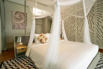 a bedroom with a white bed with a canopy at Coastal Escape Koh Yao Noi in Ko Yao Noi