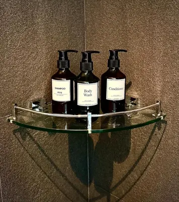 a glass shelf with three bottles on top of it at Phuket Hideaway Near Bang Tao in Laguna Phuket