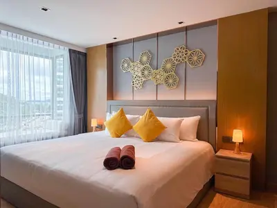 a bedroom with a bed with two shoes on it at La Vita Rawai Nai Harn Beach 5 Star 1 BDR in Rawai Beach