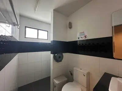 a bathroom with a toilet and a window at By the Beach Hostel in Phi Phi Don
