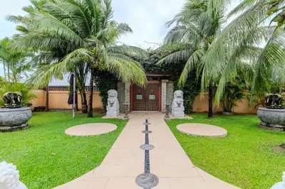 a garden with palm trees in front of a building at V225 Spacious 3BR Villa Pool and Garden Near Beach in Rawai Beach