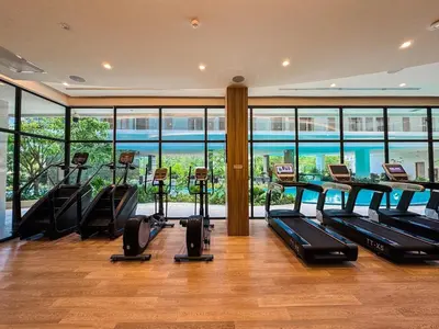 a gym with treadmills and ellipticals in a building at New Modern 1Bdr Laya 500 m to the Beach in Layan Beach