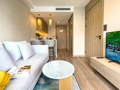 a living room with a white couch and a tv at New Modern 1Bdr Laya 500 m to the Beach in Layan Beach