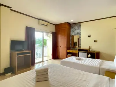 a hotel room with two beds and a television at Maap Guest House in Patong Beach